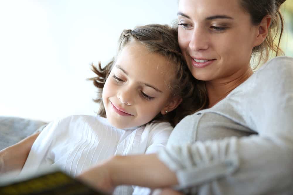 Books & Studies About Only Children: Is One Enough? 4 This is a close look at a mother and daughter reading a book on the couch.
