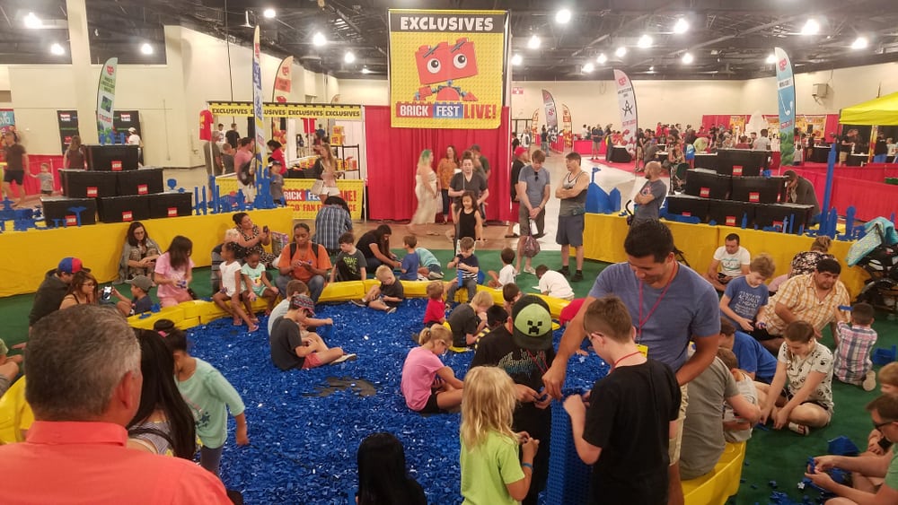 This is a close look at Legoland with lots of children playing with lego pieces.