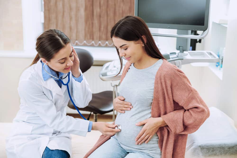 An OB-GYN checking the status of a pregnant woman's baby.