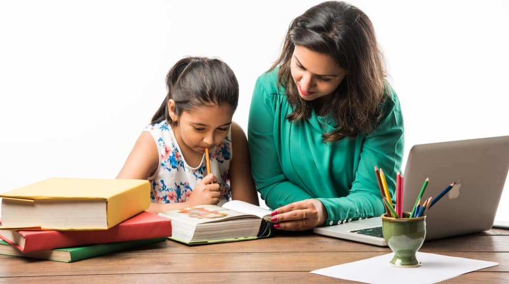This is a close look at a mother helping her daughter with her studies.