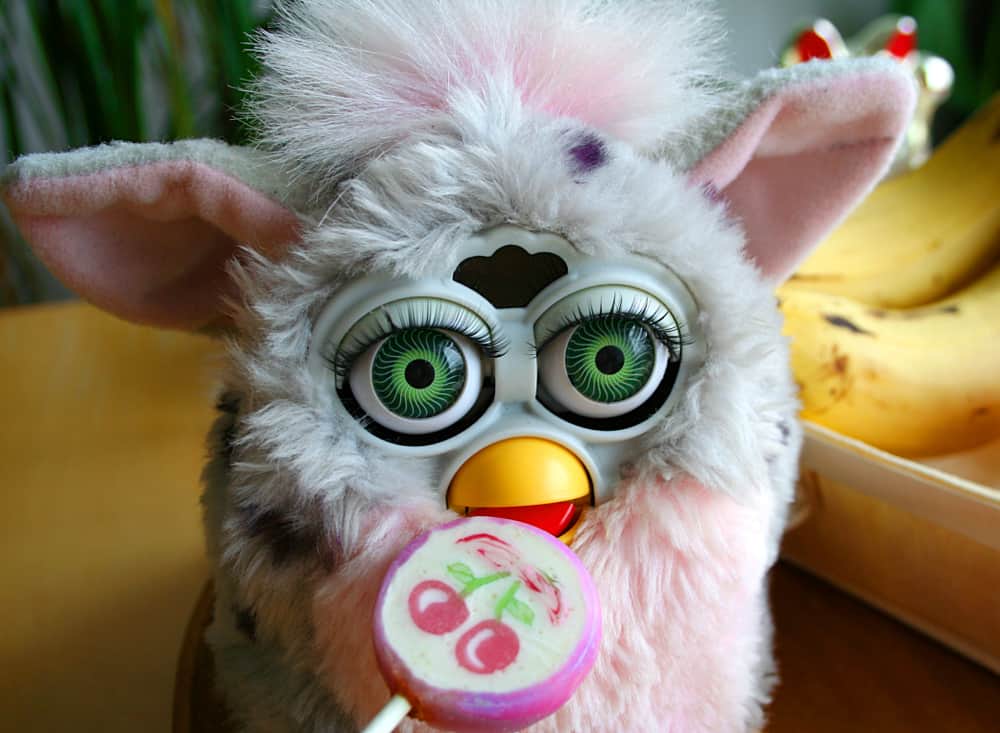 This is a close look at a Furby toy with large eyes and thick fur.