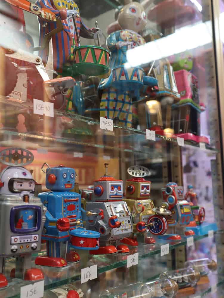 Broken Toys This is a close look at a collection of vintage tin toys on display with price tags.