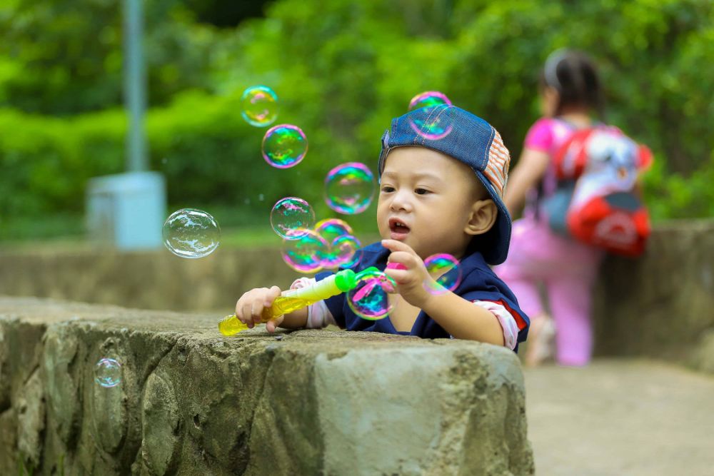 18 Fun Outdoor Activities For Babies! 3 A baby playing with bubbles.