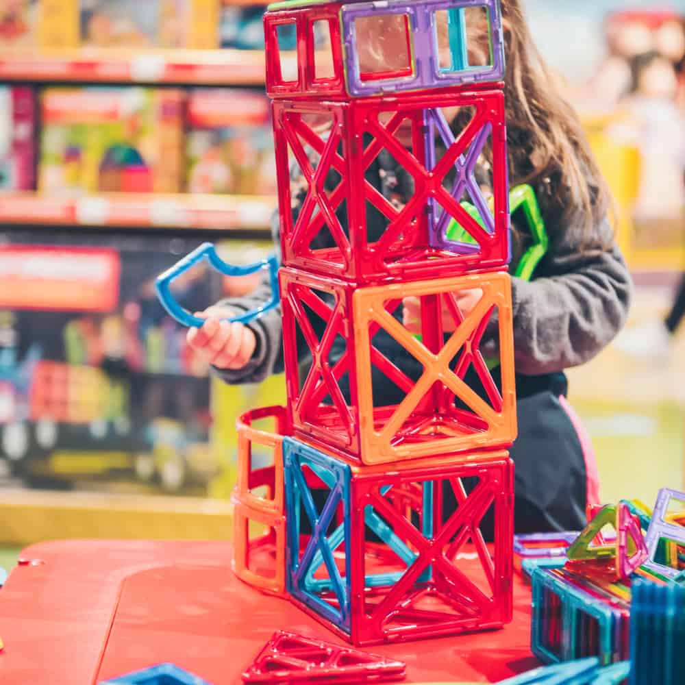 A kid playing Magformers with colorful parts. Toys similar to magformers.