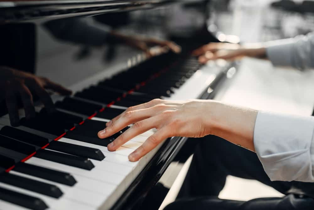 A close look at a man playing the piano. Types of pianos.
