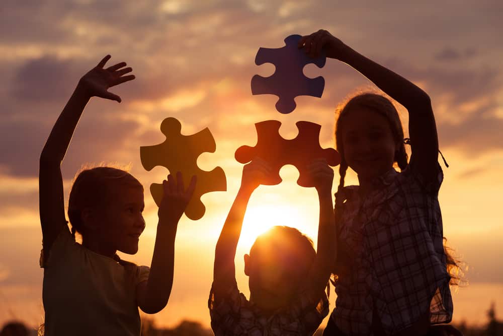 Kids playing with large puzzle pieces.