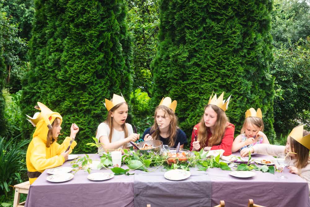 A group of kids on a backyard luncheon party.