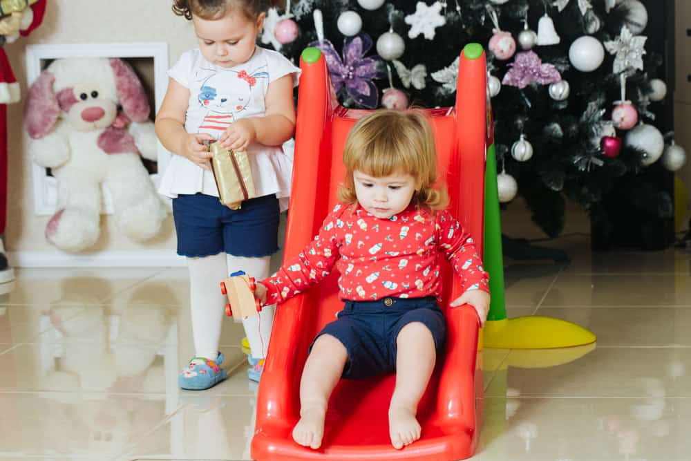 32 Cool Spinning Toys for Kids 11 Kids playing on a plastic slide.