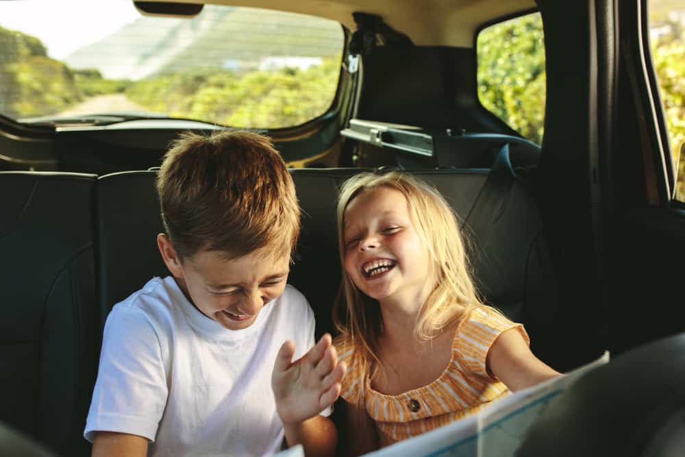 Siblings laughing in the car.