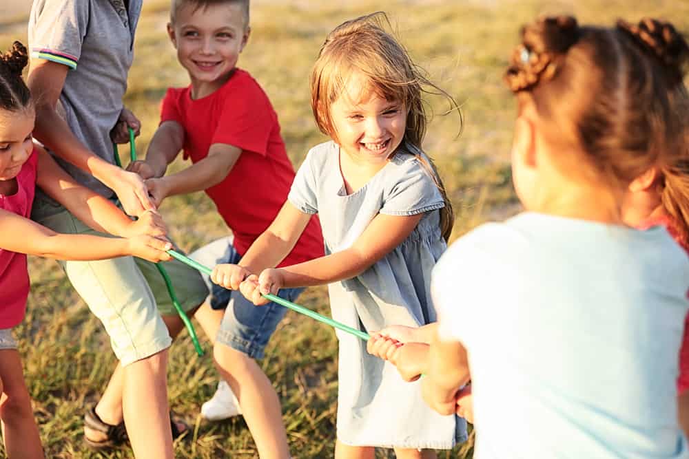 A group of kids playing tug of war.