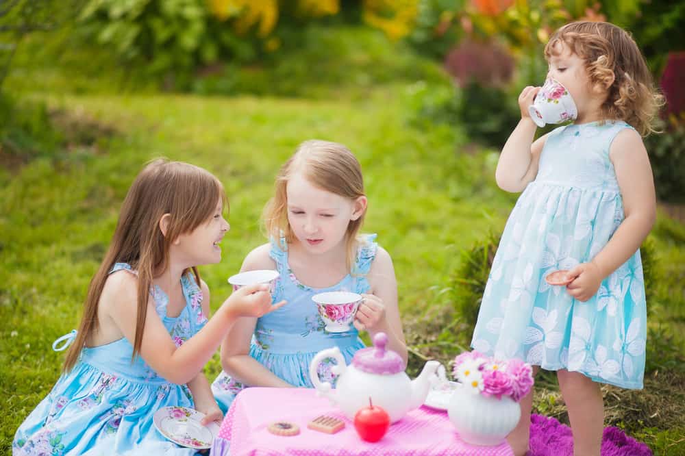 Girls having a tea party in the backyard.