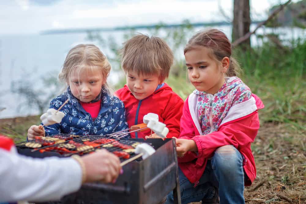 A group of kids toasting marshmallows.