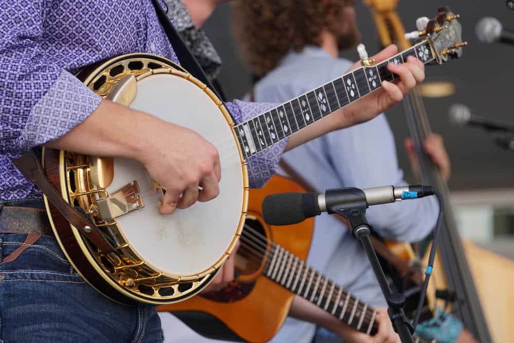 A close look at a banjo being played with a band.