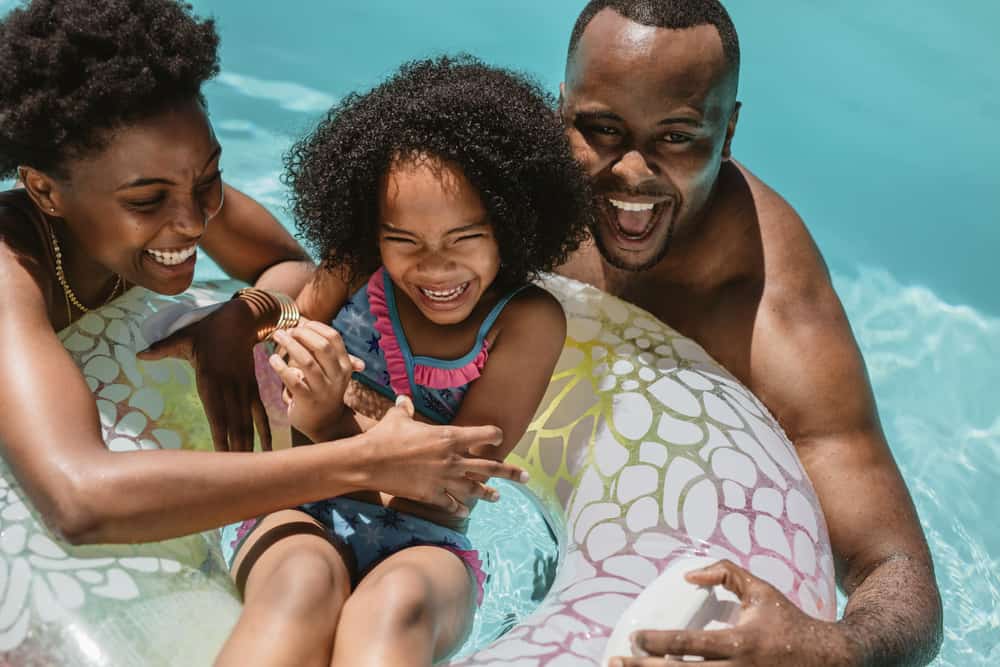 This is a close look at a family of three playing in the pool.