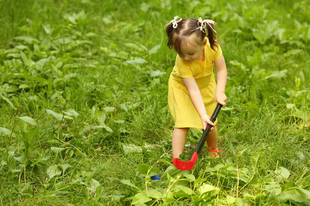 A little girl playing field hockey.