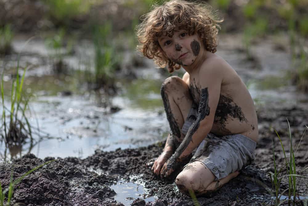 A boy playing with mud.