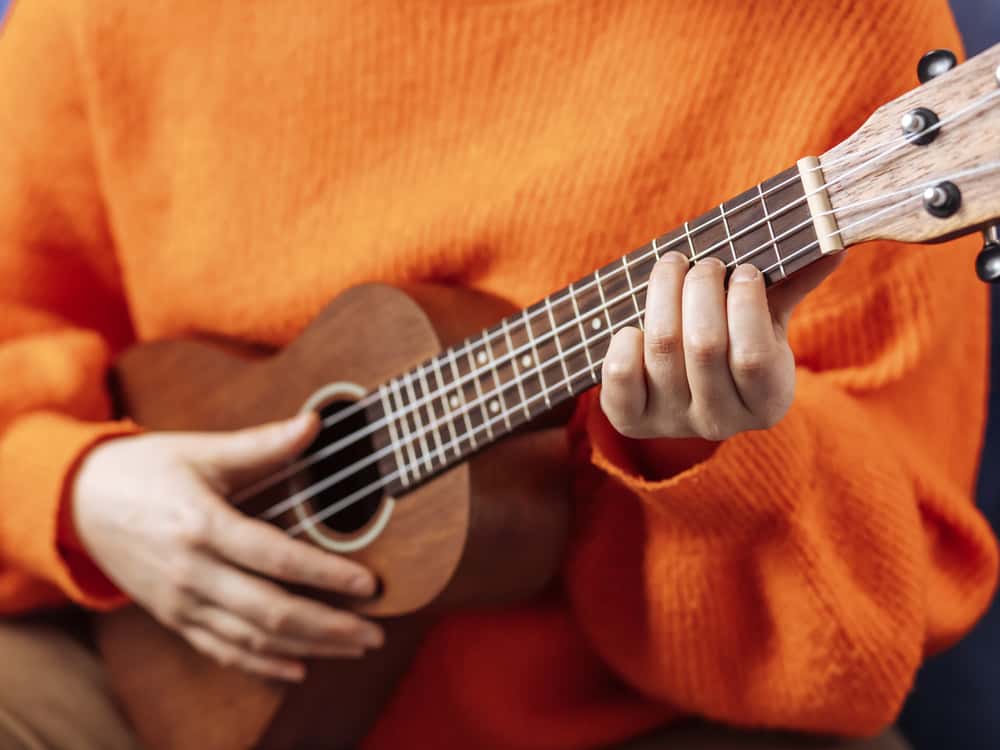 A close look at a girl playing the ukelele.