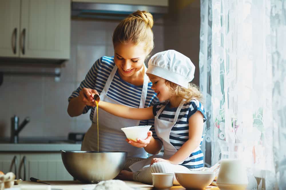 Mother and daughter baking together in the kitchen.