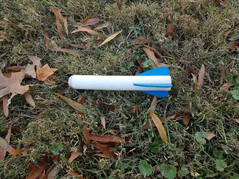 A stomp rocket on the grass lawn of the backyard.