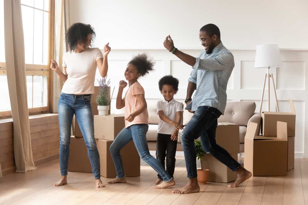 A family dancing together in the living room.