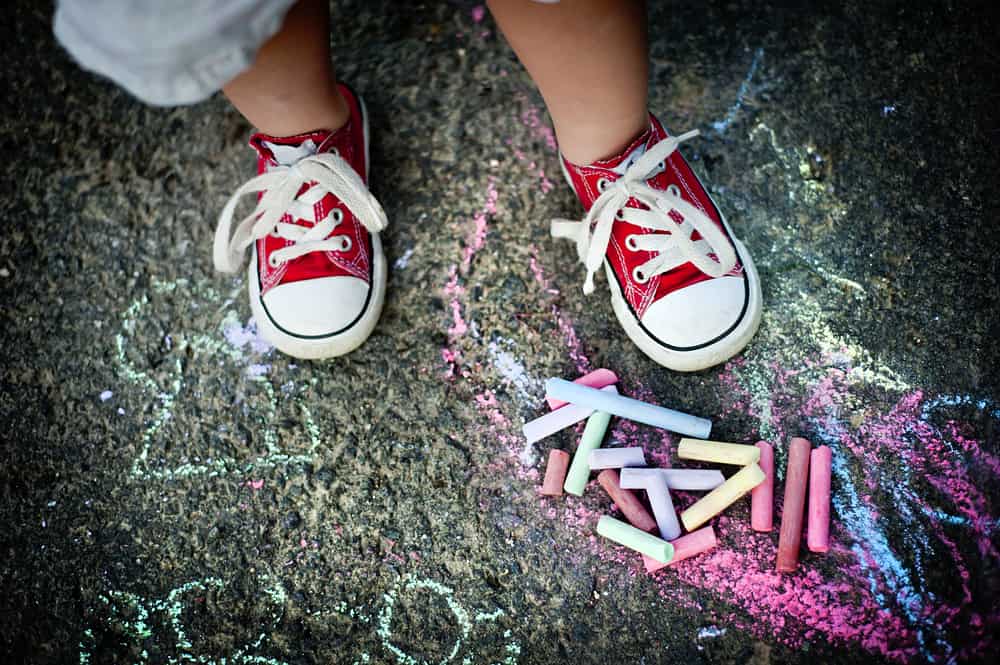 A toddler wearing a pair of canvas shoes.