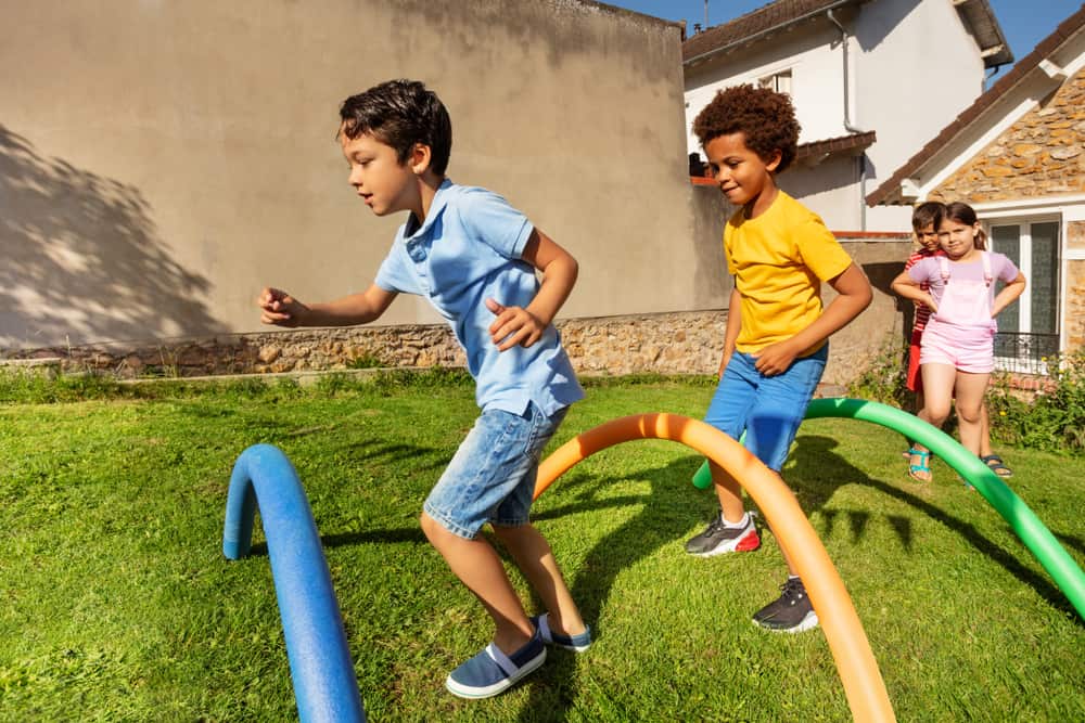 A group of kids playing on the obstacle course.