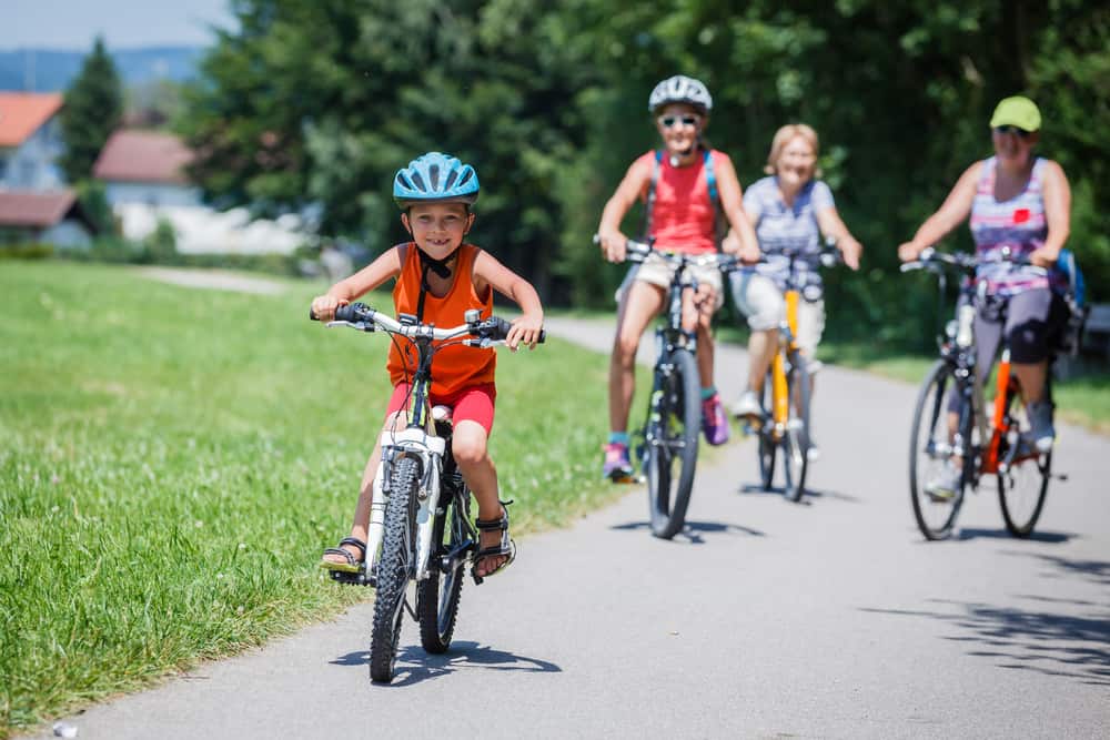 A family riding their bikes in the park.