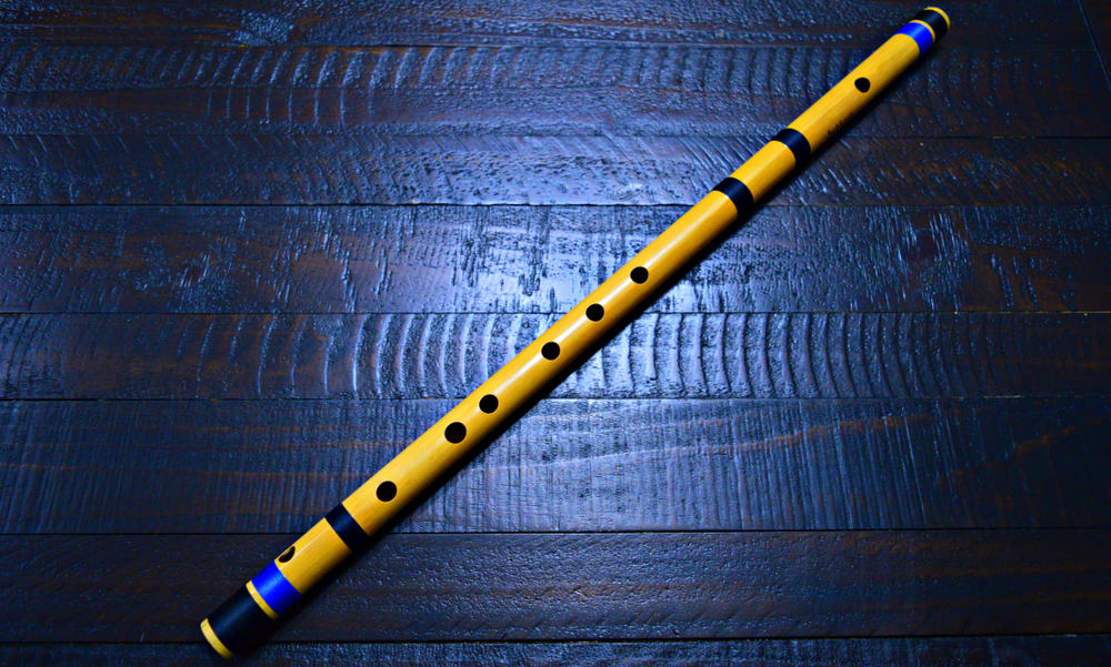 This is a bansuri flute on a hardwood flooring.