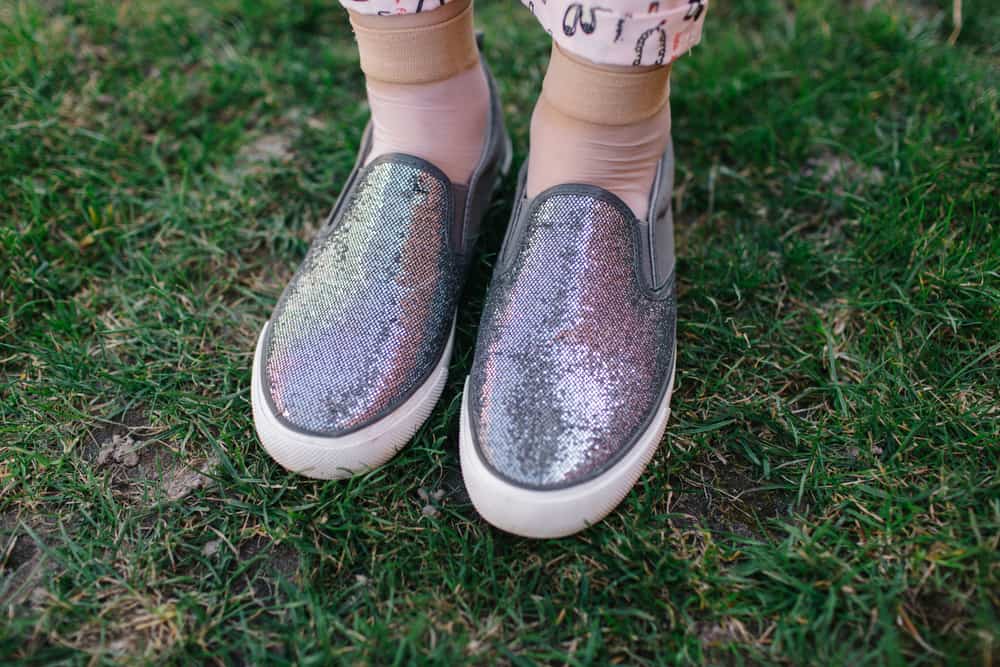 A pair of colorful and sparkly slip-on shoes.