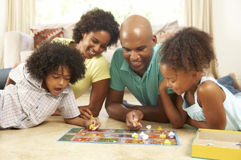 A family on the floor playing a board game together.