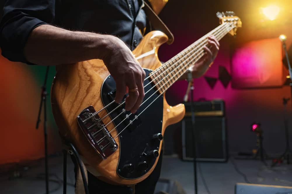 A close look at a bass guitar being played.
