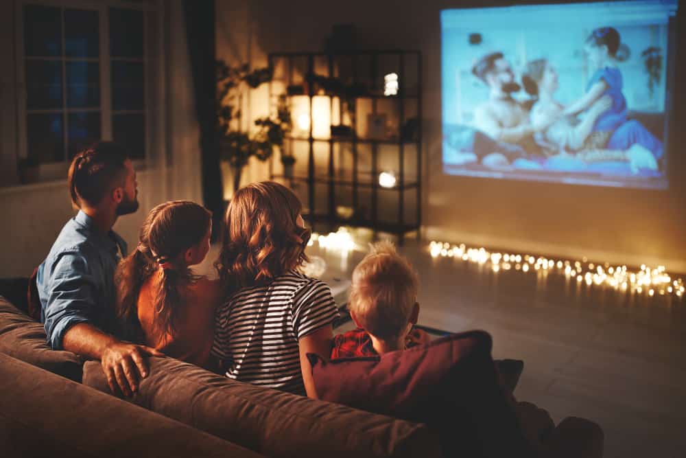 A family of four watching a movie together.