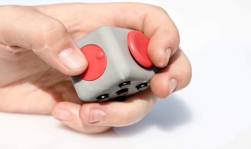 32 Cool Spinning Toys for Kids 7 A hand holding a dice fidget cube.