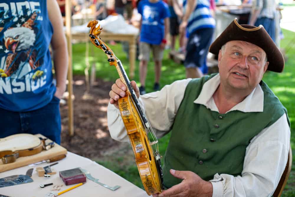 8 Popular Types of Violins 7 A man holding up a hardanger fiddle violin.