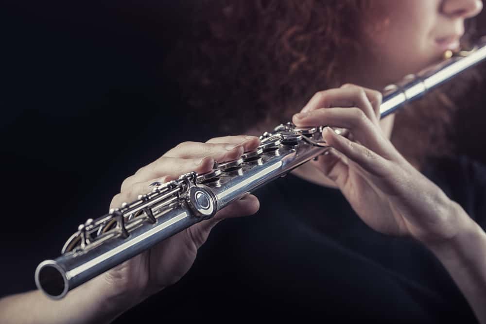This is a close look at a woman playing the flute.