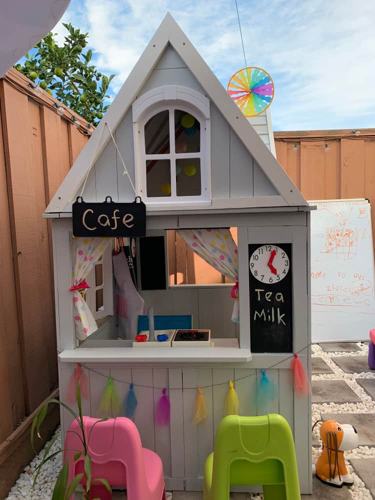 A makeshift wooden playhouse with cafe.