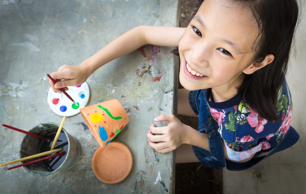Girl painting the flower pots.