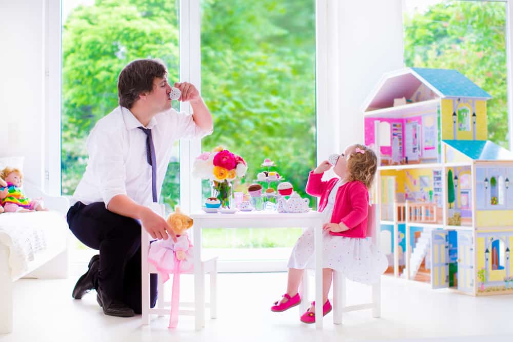 A father and a daughter having a play tea party.