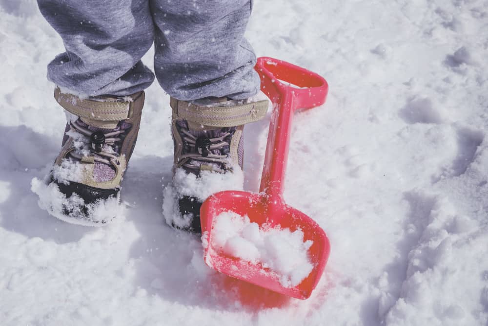 A close look at a kid wearing a pair of snow boots.