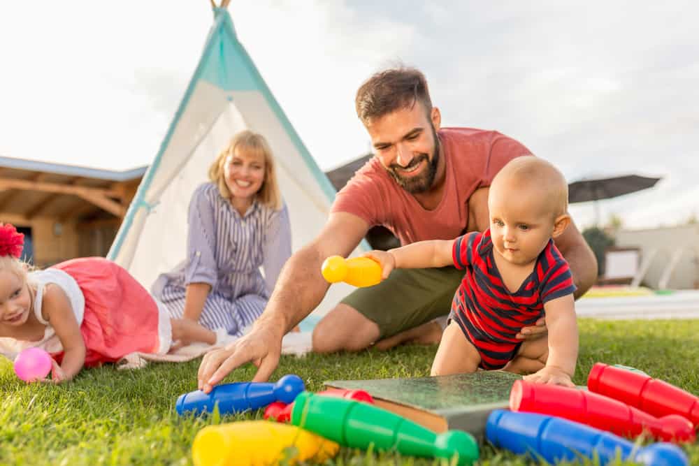 A family playing with a plastic bowling toy.