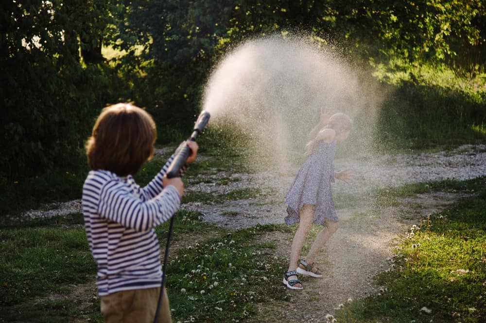 Kids playing with a water sprinkler.