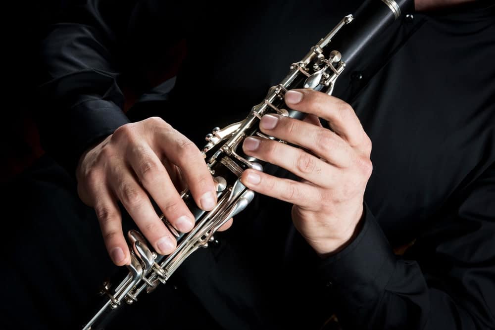 Cropped image of a musician's hands on a clarinet.