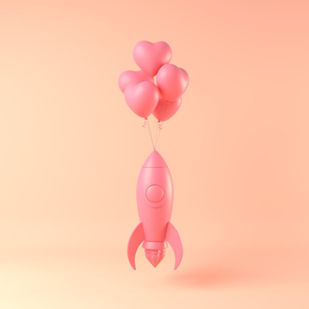 Pink balloon rocket attached to a cluster of pink heart-shaped balloons.
