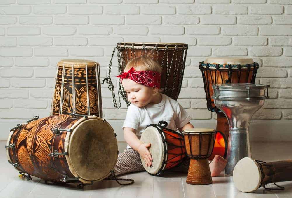 11 Popular Types of Drums Explained 1 Baby playing with various types of drums.