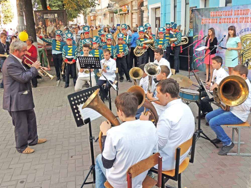 Street choir playing different musical instruments including trumpets, drums, and helicon tuba.