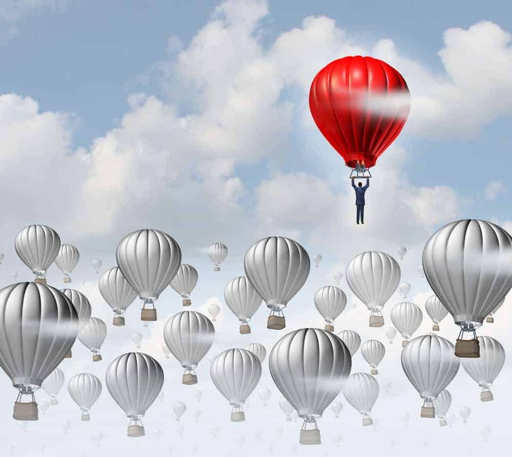A man flies away in a red hopper balloon.