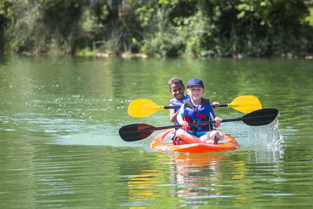 Little boys kayaking down the river.