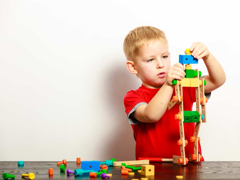 Little boy playing with colorful building blocks.