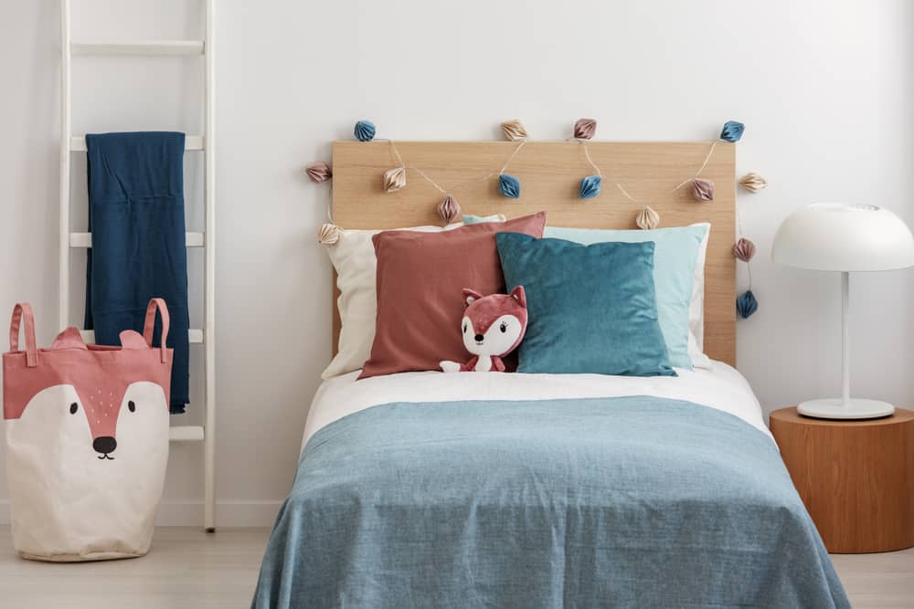 13 Popular Types of Beds for Kids 1 Kid's bed with a velvet pillows and a plush fox.