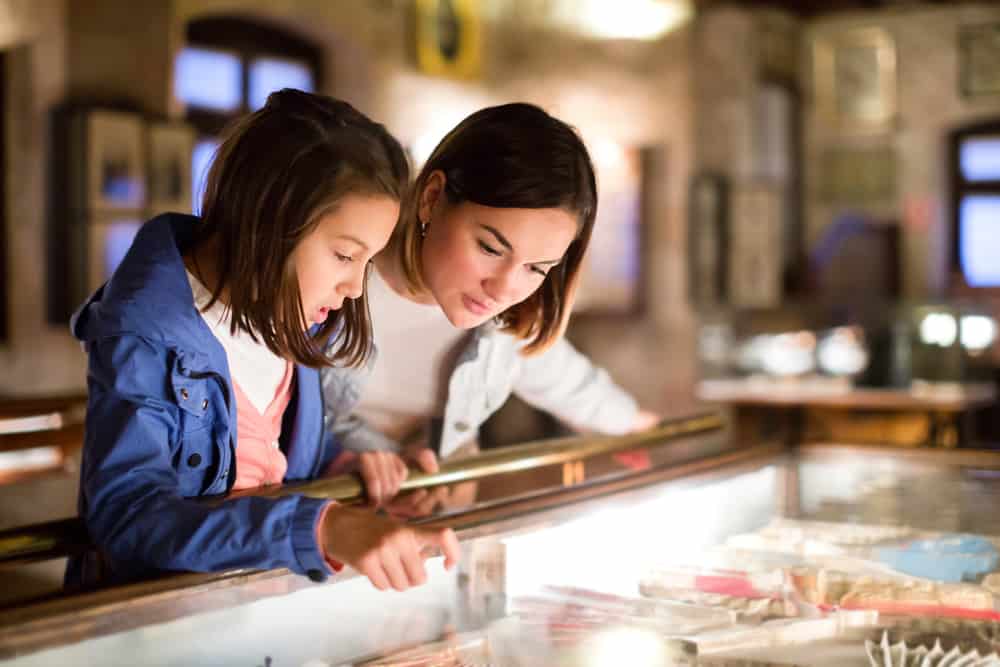 Mother and daughter touring inside a museum.
